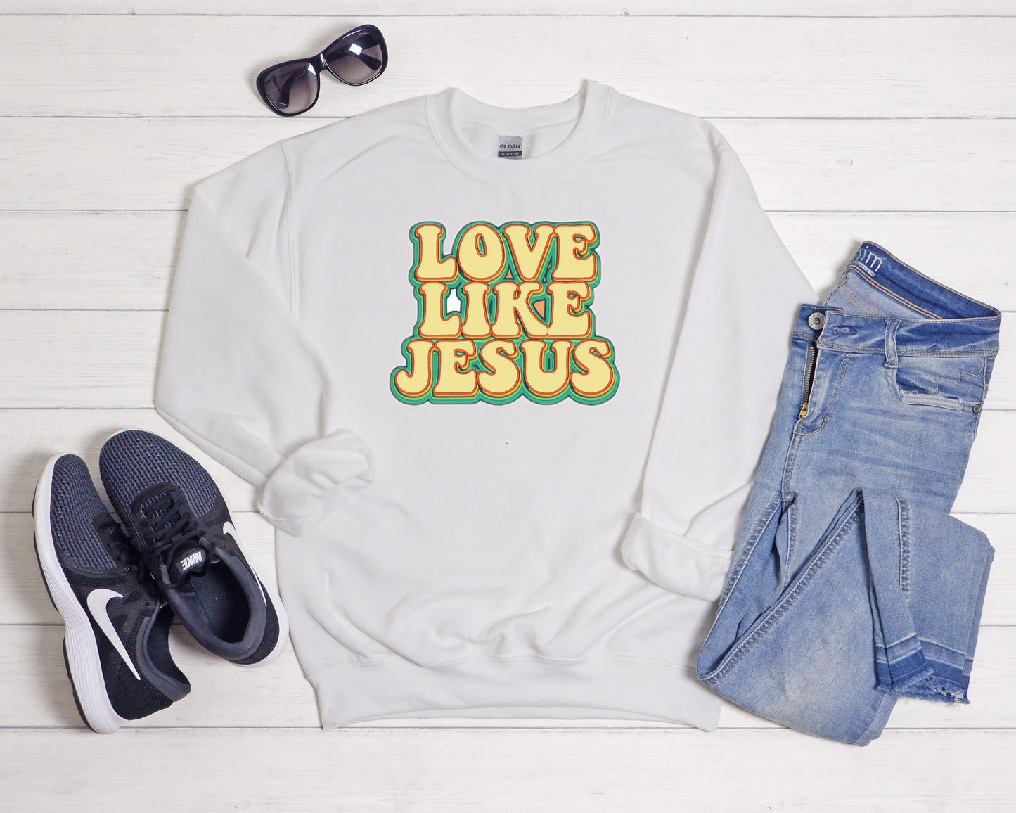 Sons & Daughters Love Like Jesus crew sweatshirt with printed message and soft fabric, shown in a close-up on a white background.