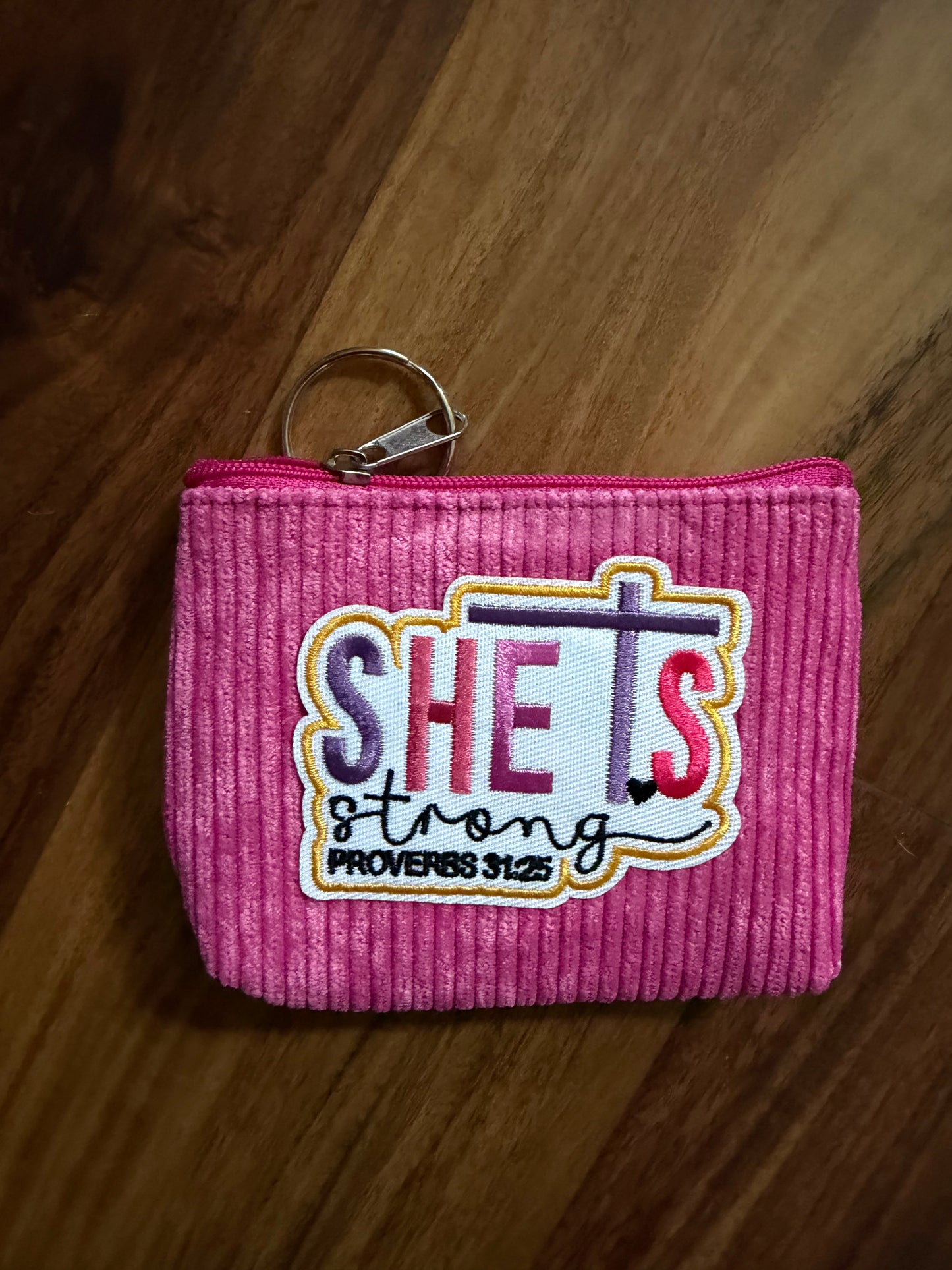 Colorful corduroy coin purse with Christian patch from Sons & Daughters accessories collection, featuring vibrant fabric and patch detail.