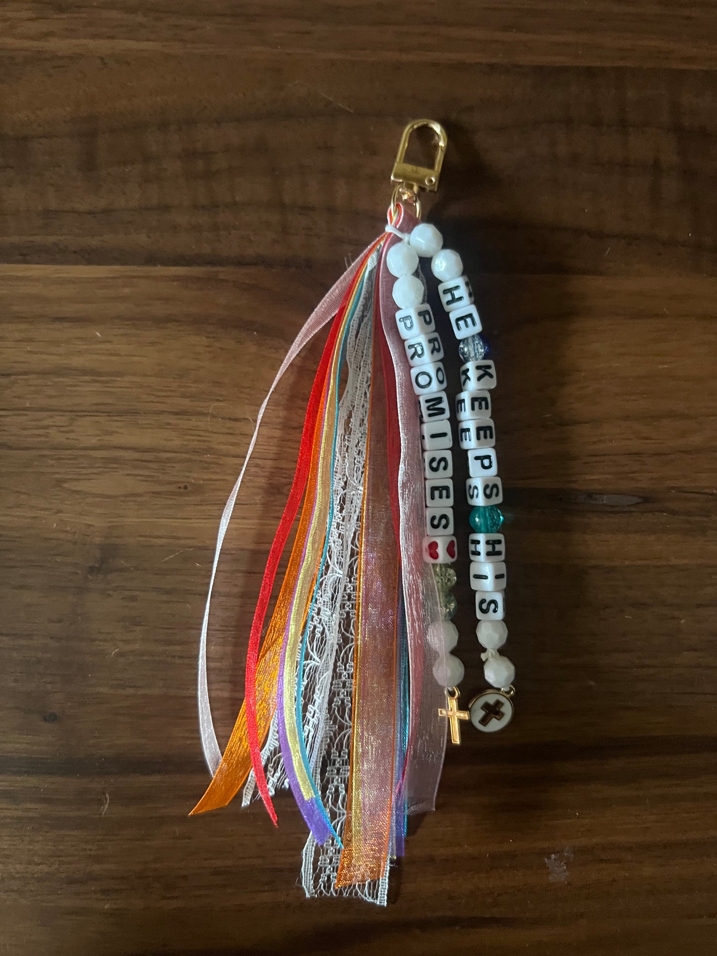 Colorful Sons & Daughters "He Keeps His Promises" keychain with engraved message and metal keyring.