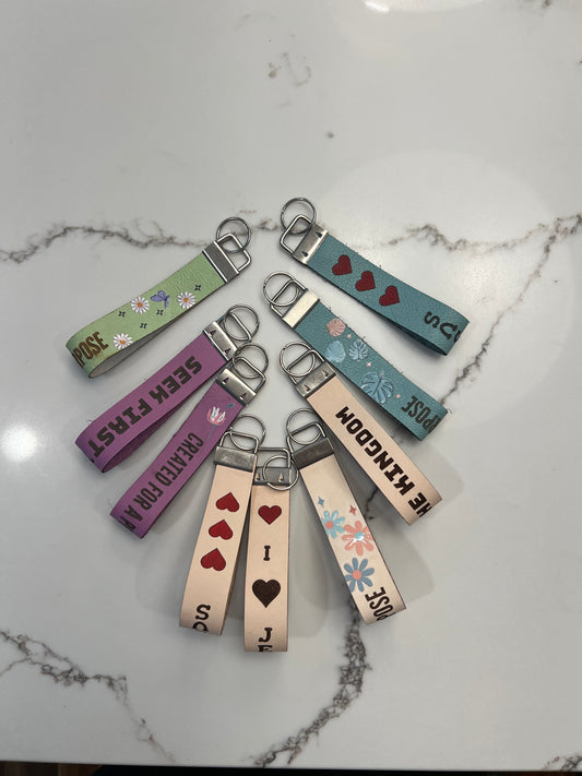 Leather Christian-themed keychain by Sons & Daughters featuring engraved religious symbols and a durable metal keyring.