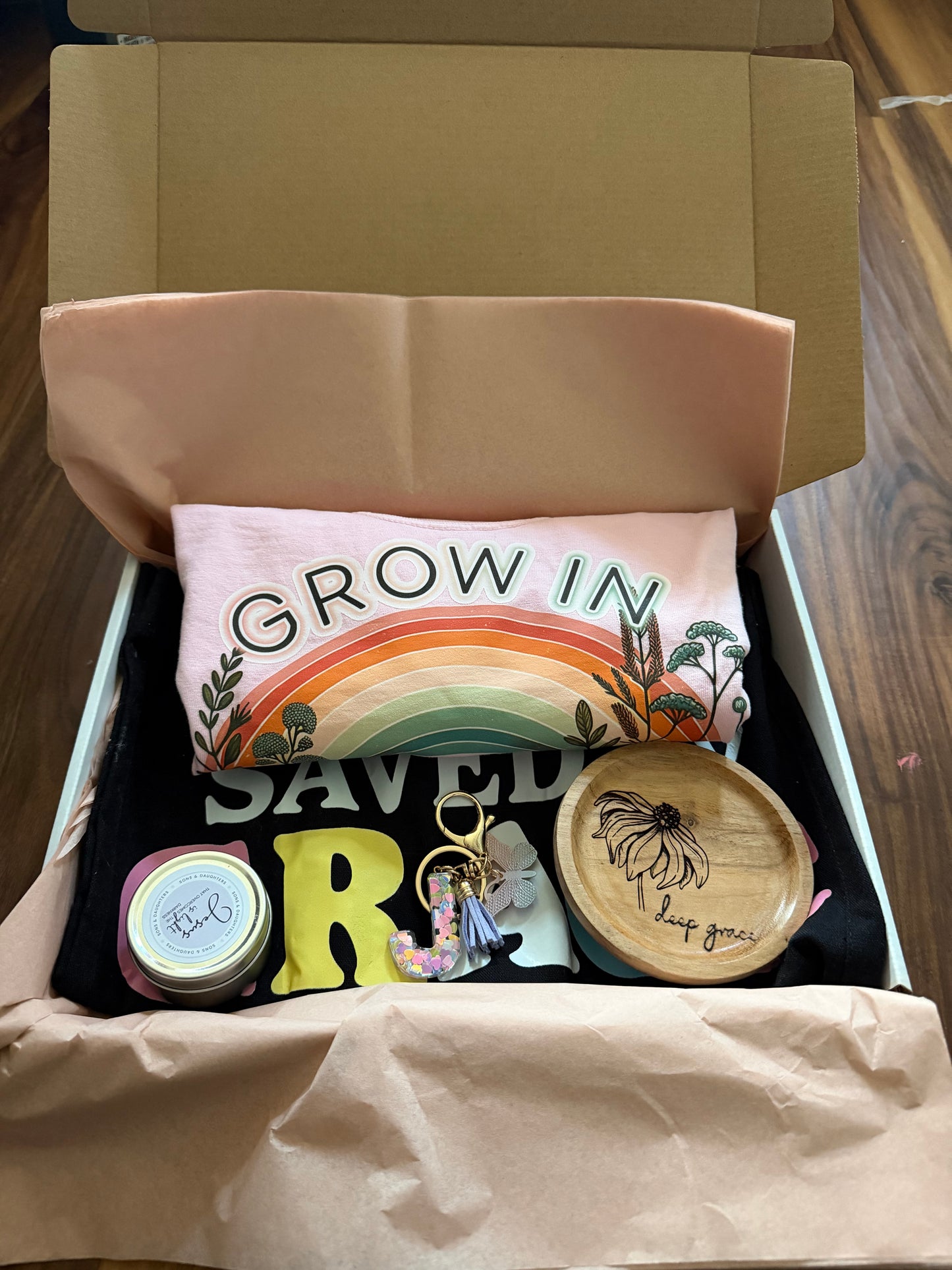 Mystery gift box featuring a Grace-themed spiritual soul care kit with a T-shirt and bag from Sons & Daughters.