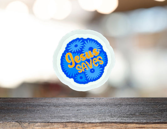 Close-up of a "Jesus Saves" graphic design on a T-shirt, featuring bold white text against a dark background.