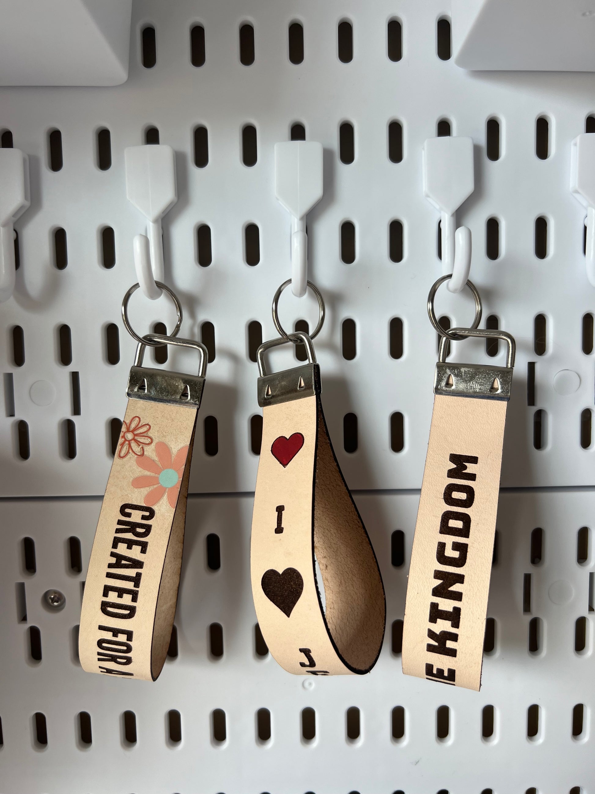 Leather Christian-themed keychain by Sons & Daughters featuring religious symbols and detailed craftsmanship.