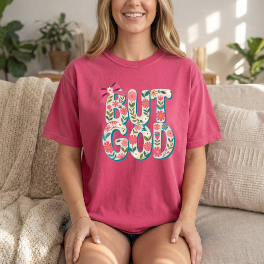 Blush front view of Sons & Daughters But God floral Christian T-shirt with inspirational Bible verse, soft cotton faith apparel.