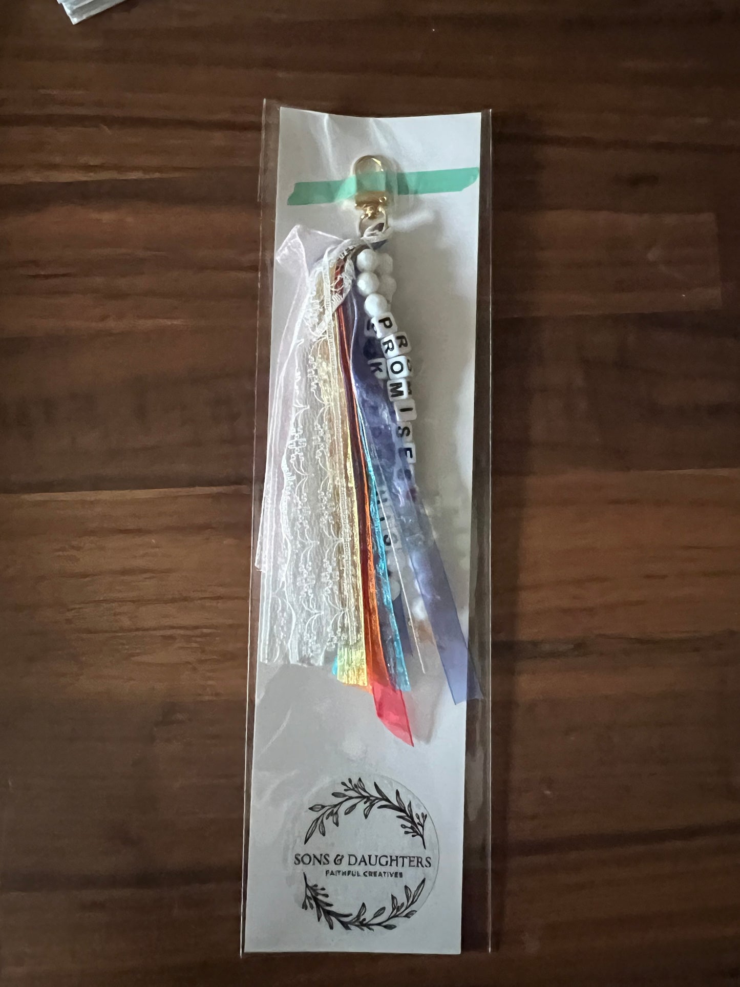 Vibrant Sons & Daughters He Keeps His Promises keychain with colorful design and engraved message, hanging on a keyring.
