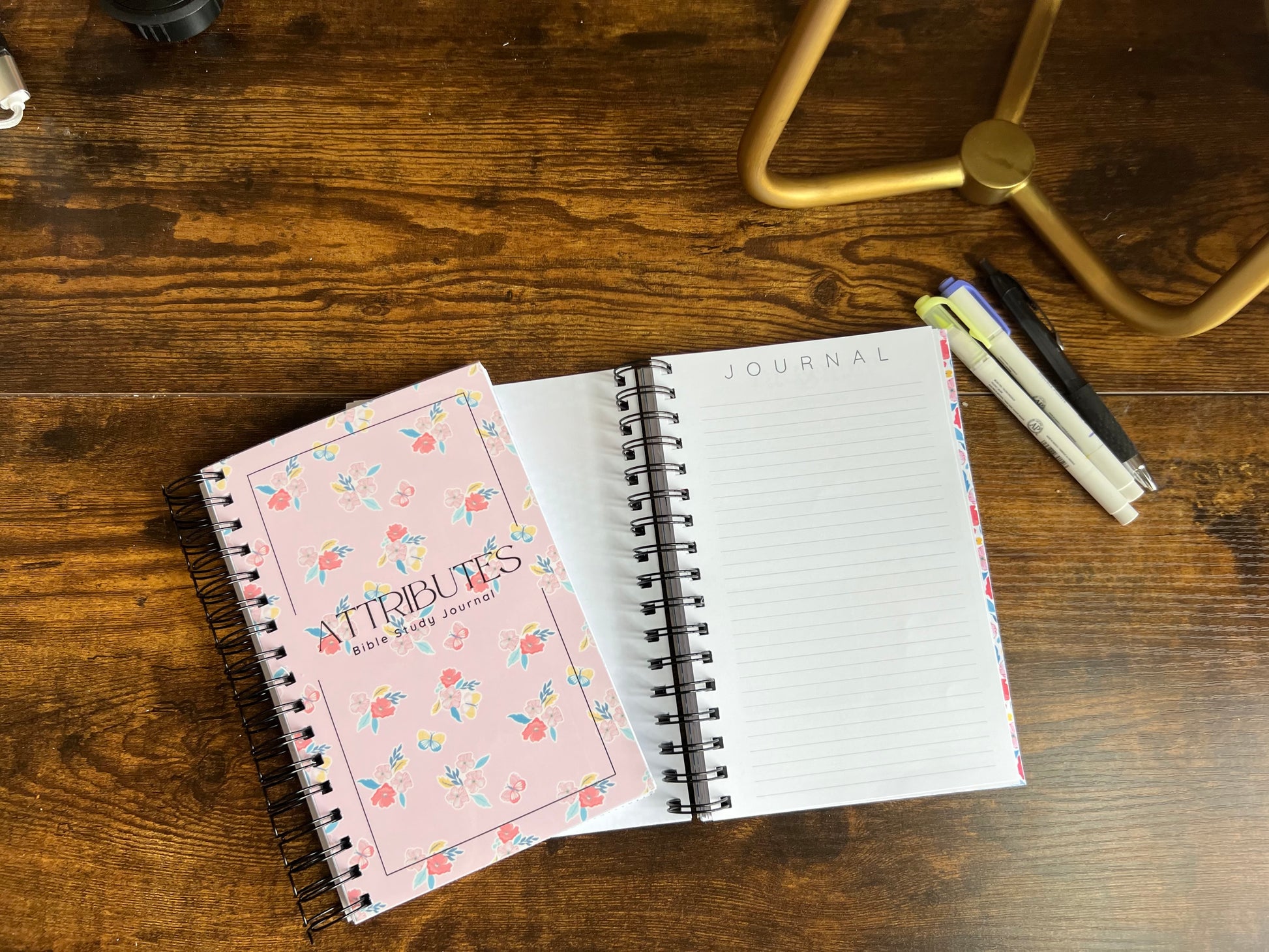 Spiral edition Bible study journal titled "Attributes of God" by Sons & Daughters, featuring lined pages and religious design elements.