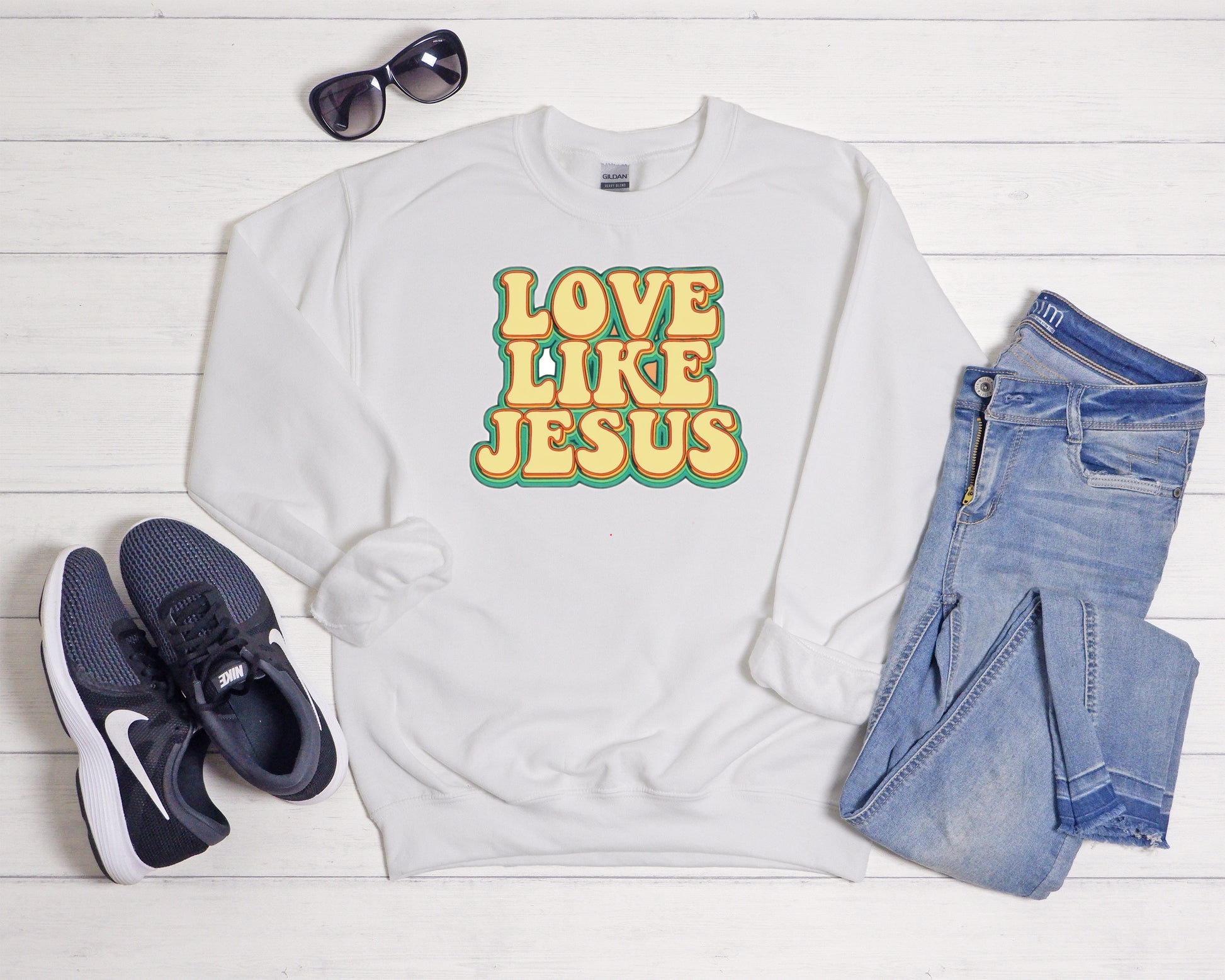 Sons & Daughters Love Like Jesus crew sweatshirt with printed message and soft fabric, shown in a close-up on a white background.