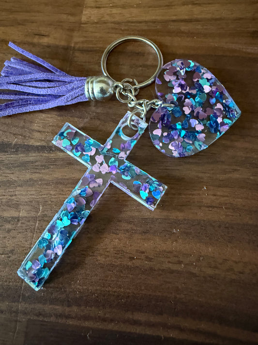 Acrylic glitter keychains featuring a cross and heart design from Sons & Daughters accessories collection.