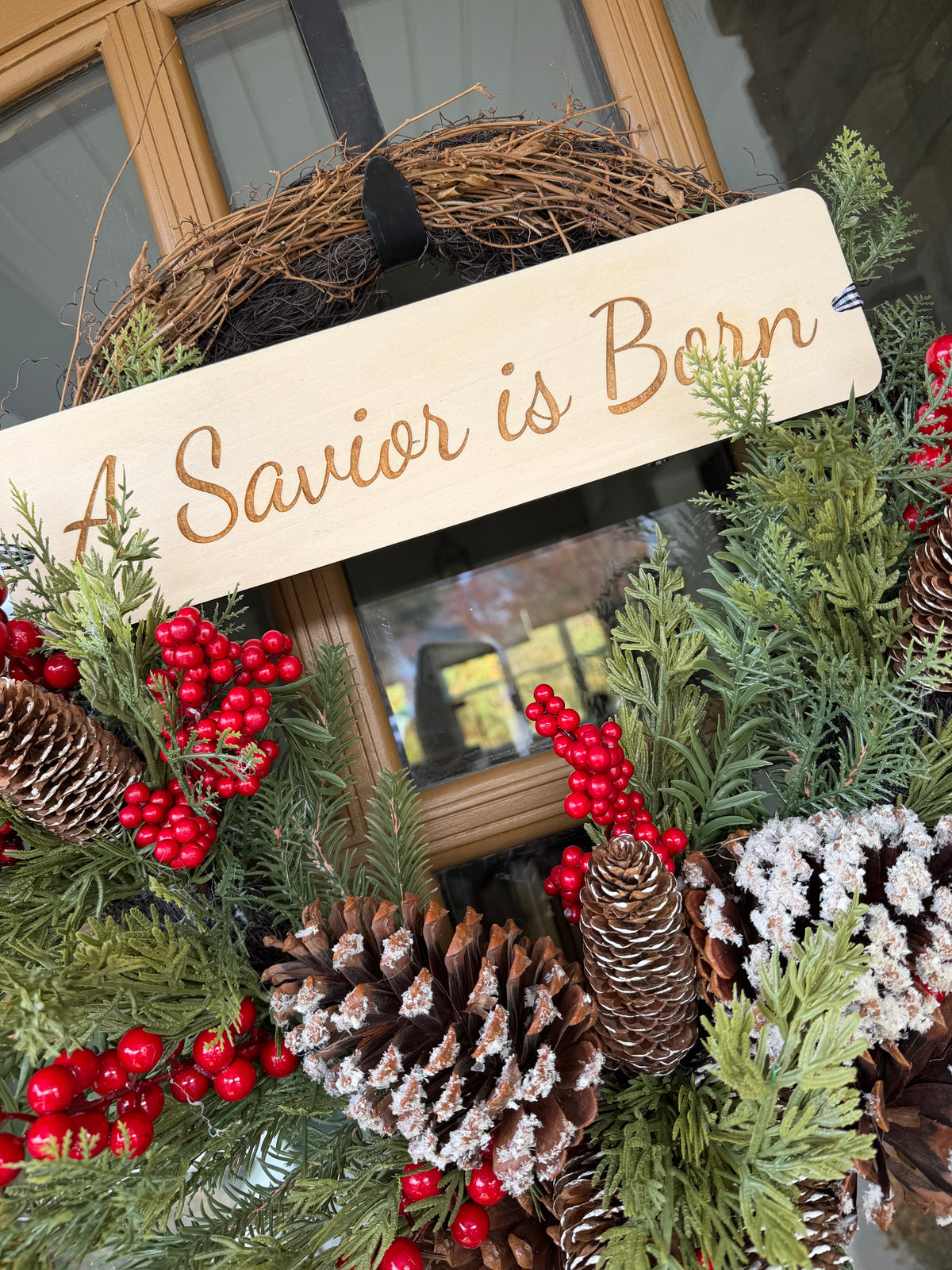 A Savior Is Born door wreath by Sons & Daughters with festive Christian holiday lettering