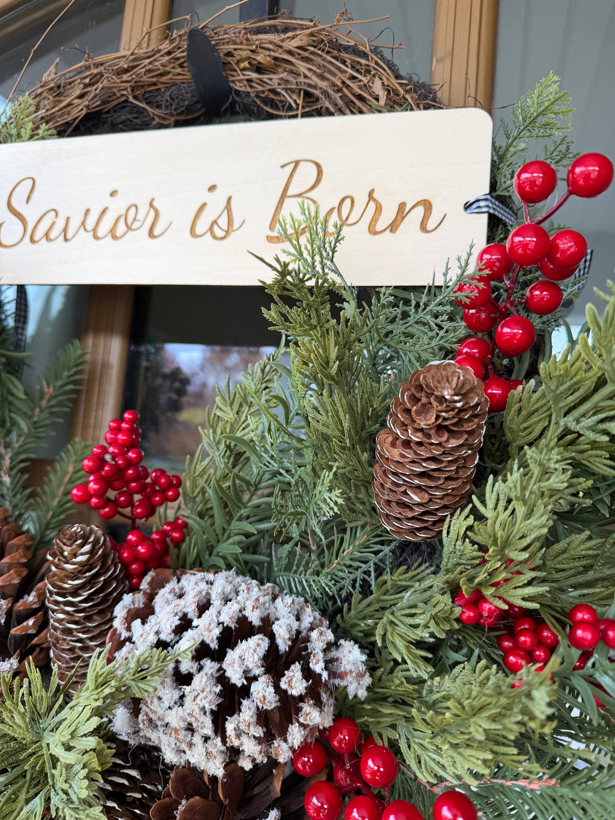 Sons & Daughters “A Savior Is Born” door wreath with festive Christian holiday design