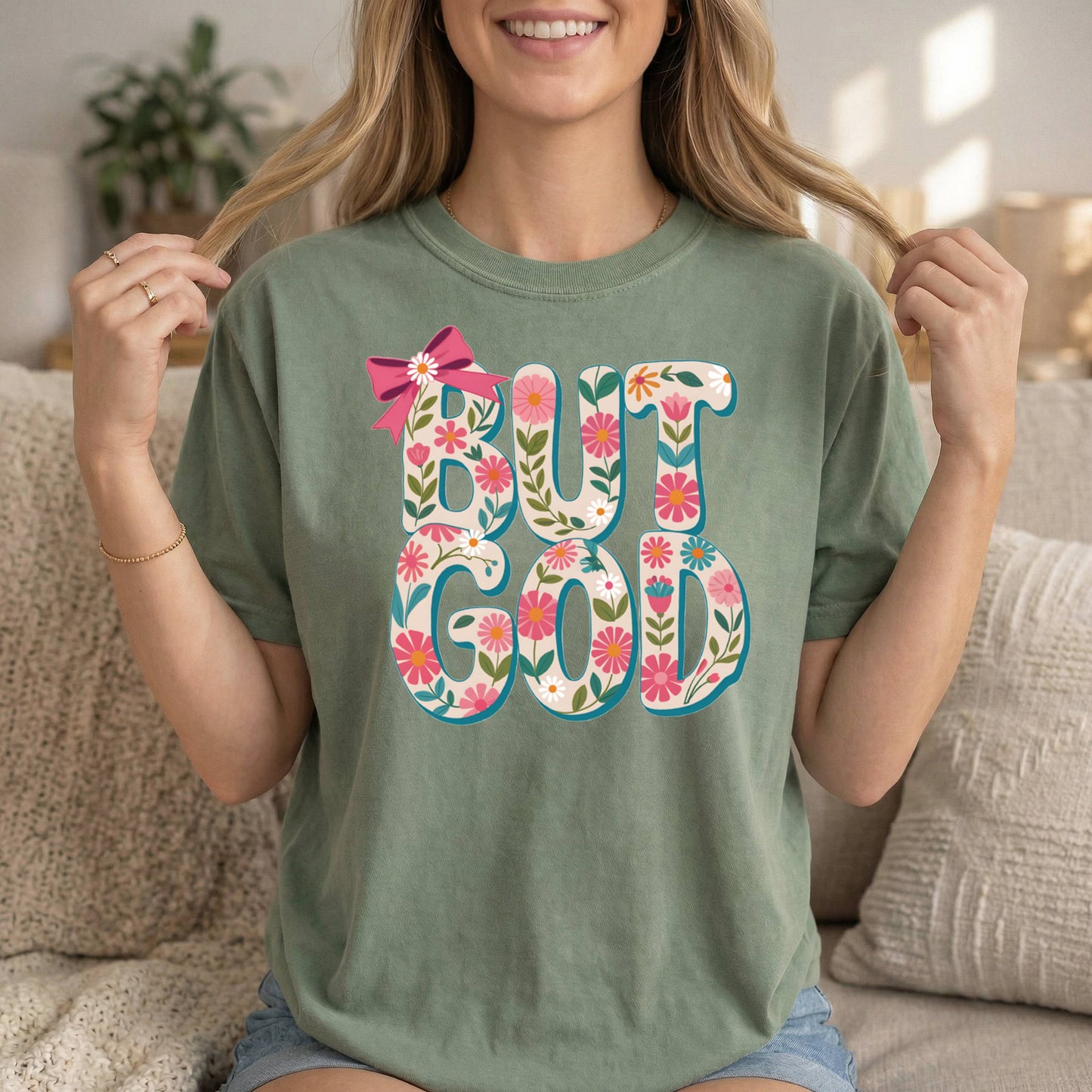 Sage-colored Christian T-shirt with "But God" floral design and Bible verse, soft cotton faith apparel by Sons & Daughters.
