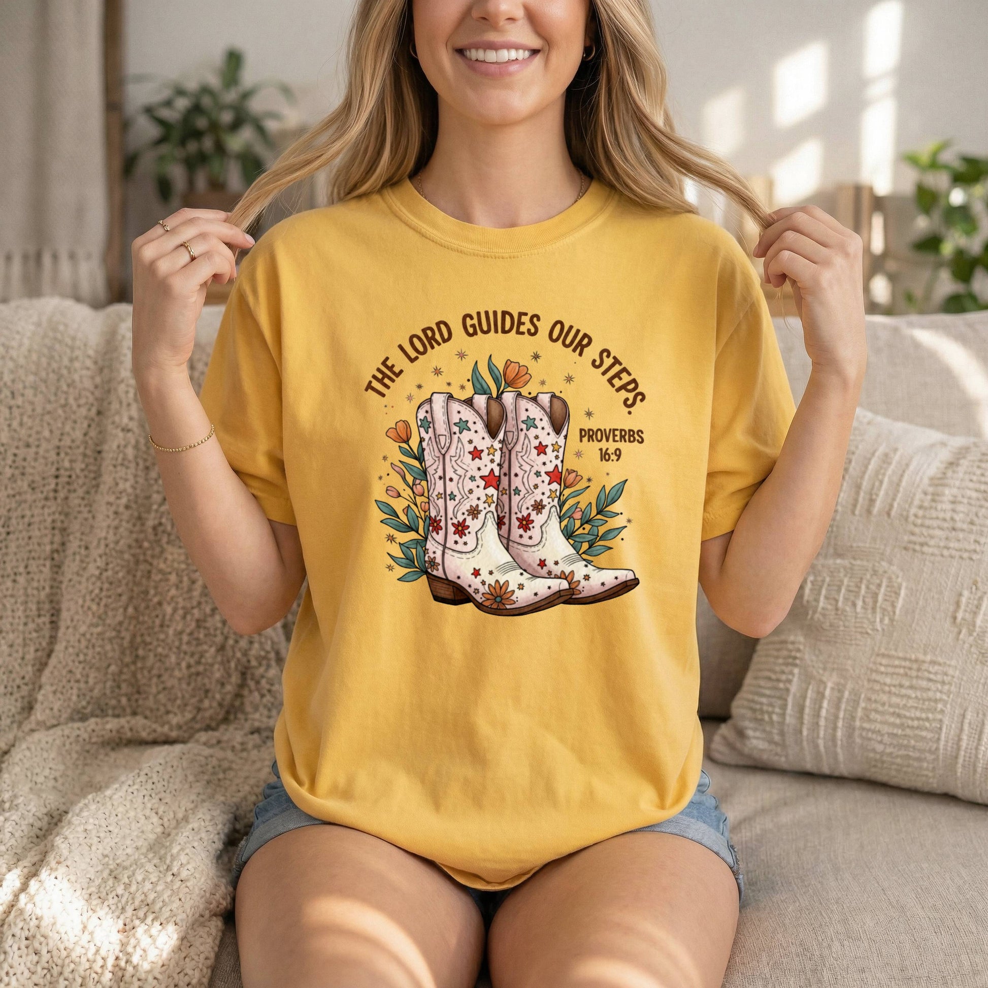 Comfort Colors cowgirl T-shirt with sunflower design, inspirational Bible verse Proverbs 16:9, and Western-style boots for women.