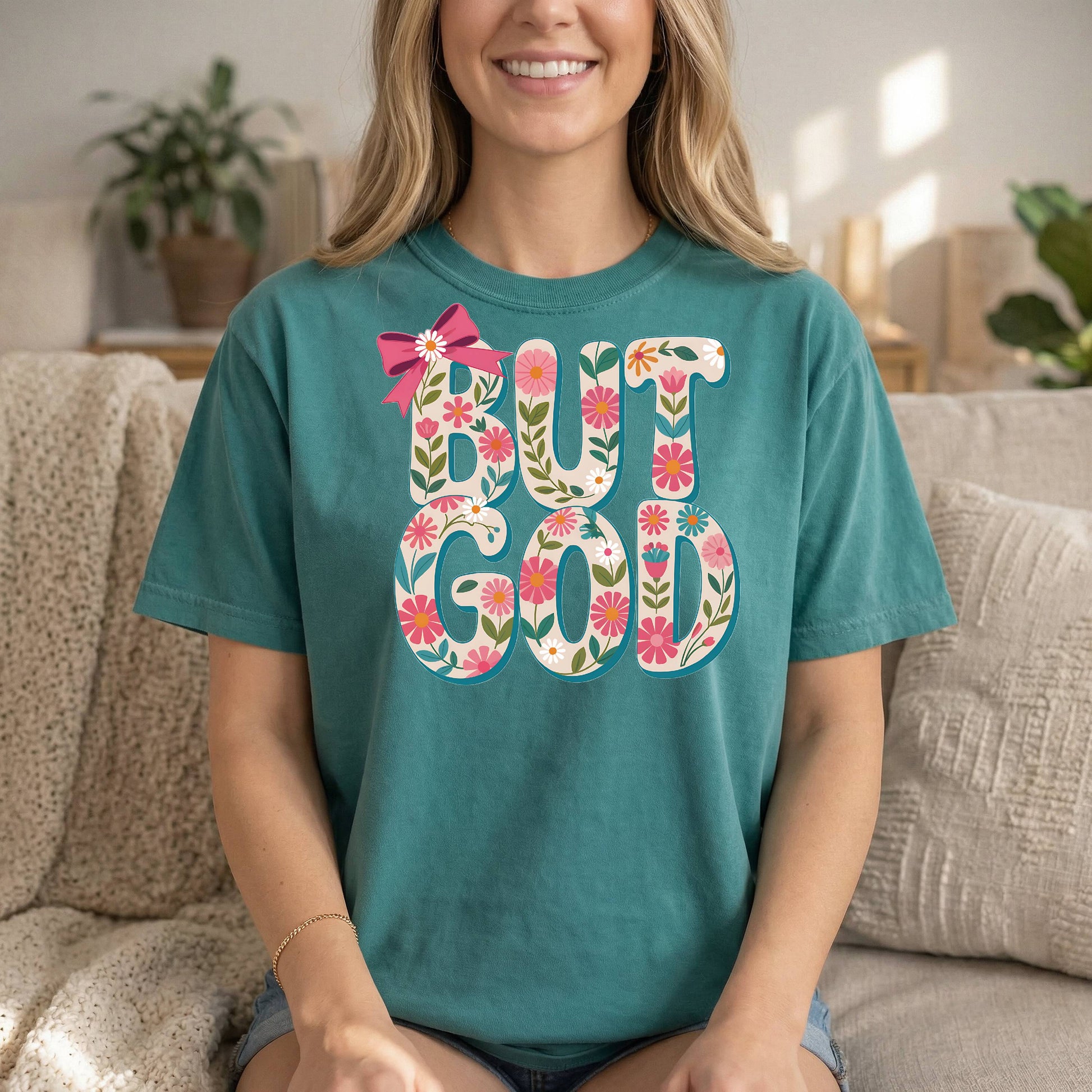 Teal Christian T-shirt by Sons & Daughters with "But God" floral design and inspirational Bible verse on soft cotton fabric.