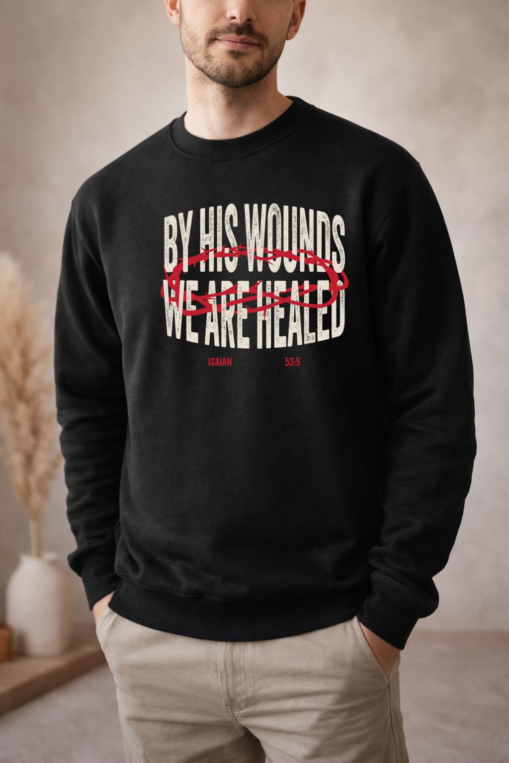 Sons & Daughters "By His Wounds" sweatshirt featuring religious text and a casual, comfortable fit in charcoal gray.
